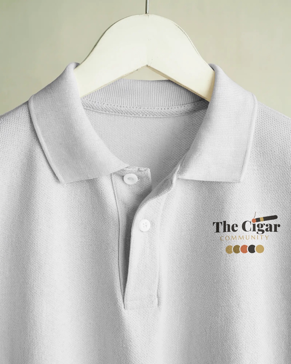 Close-up of the embroidered Cigar Community lockup on the white polo